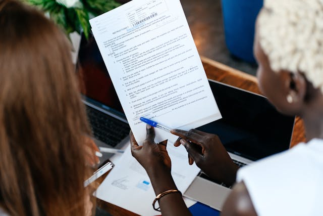 Employees review a piece of paper with a pen in hand