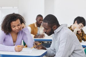 Black teacher helps a Black student with an assignment. Photo from Pexels/Andy Barbour.