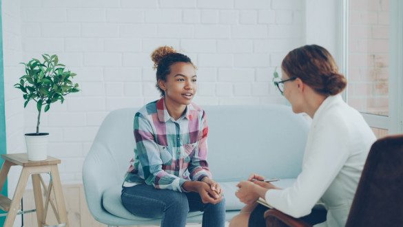 Two women talking in a modern office setting. Photo by Vitaly Gariev on Unsplash.