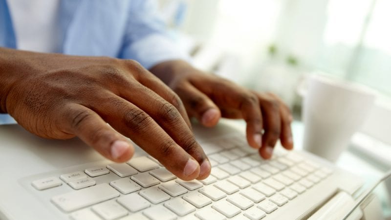 student hands typing on a keyboard