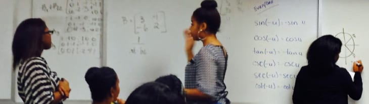 spellman students at whiteboard doing math