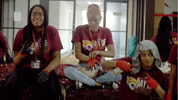 Students prepare for hands-on work wearing protective gloves.