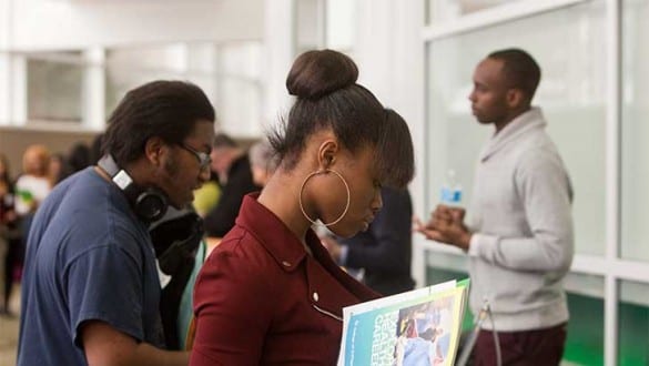 Group of students reading materials during a college career fair