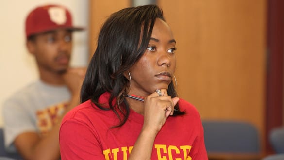 A female Tuskegee student listens intently in class